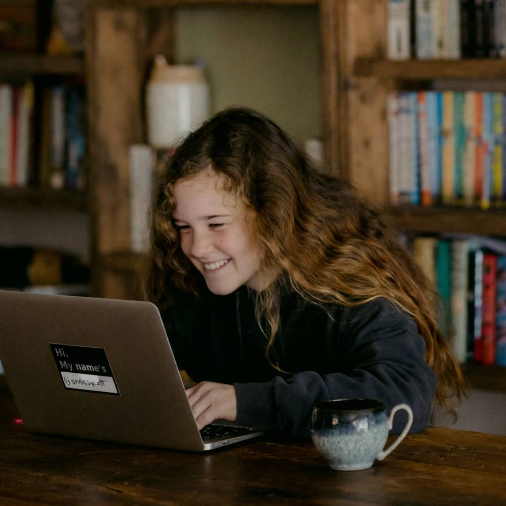 Excited student with a laptop, bags packed, ready to travel and feeling confident